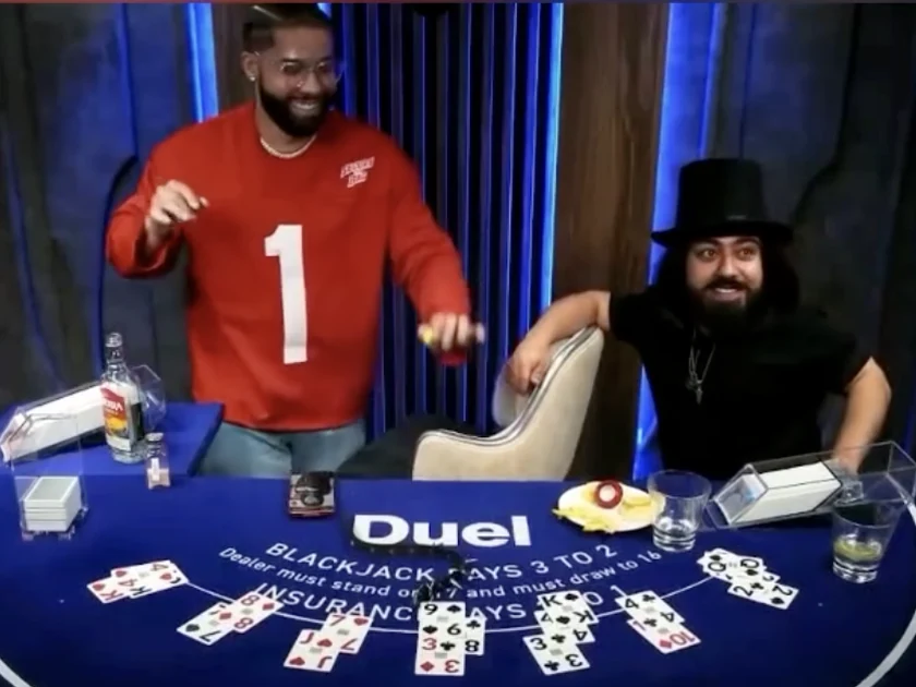 The figure the Duel table bills as Dealer Drake, beside the host in the top hat